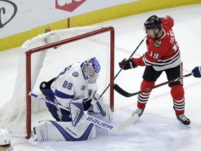 Tampa Bay Lightning goaltender Andrei Vasilevskiy (88) makes a save as Chicago Blackhawks' Jonathan Toews tries to knock the puck loose during the first period of an NHL hockey game Monday, Jan. 22, 2018, in Chicago.