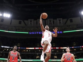 Houston Rockets' Chris Paul (3) scores between Chicago Bulls' Justin Holiday (7) and Paul Zipser during the second half of an NBA basketball game Monday, Jan. 8, 2018, in Chicago.