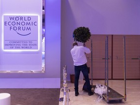 A worker places a plant during preparations for the 48th annual meeting of the World Economic Forum, WEF, in Davos, Switzerland, Sunday, Jan. 21, 2018. The meeting brings together entrepreneurs, scientists, chief executives and political leaders from Jan. 23 to 26.