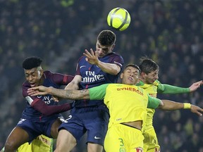 PSG's Thomas Meunier jumps for a header with Nantes' defender Diego Carlos during their French League One soccer match, in Nantes, western France, Sunday, Jan. 14, 2018.