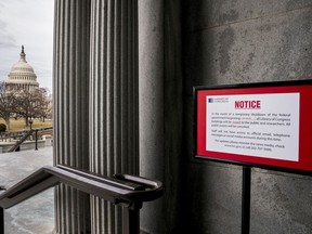 The dome of the Capitol Building is visible at left of a closure sign that is posted outside of the Library of Congress during a government shutdown in Washington, Monday, Jan. 22, 2018.