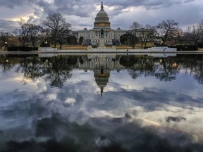 Clouds are reflected in the U.S. Capitol reflecting pool at daybreak in Washington as Day Three of the government shutdown continues, Monday, Jan. 22, 2018.