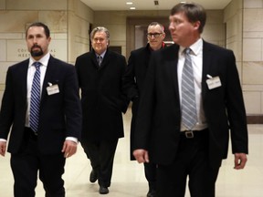 Former White House strategist Steve Bannon, second from left, is escorted from a House Intelligence Committee meeting where he was interviewed behind closed doors on Capitol Hill, Tuesday, Jan. 16, 2018, in Washington.