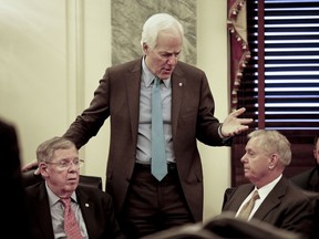 Senate Majority Whip Sen. John Cornyn, R-Texas, center, talks with Sen. Johnny Isakson, R-Ga., left, and Sen. Lindsey Graham, R-S.C., right, before the start of a meeting on immigration Wednesday, Jan. 24, 2018 on Capitol Hill in Washington.