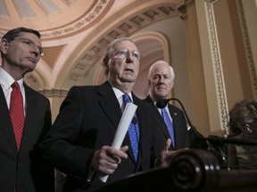 Senate Majority Leader Mitch McConnell, R-Ky., flanked by Sen. John Barrasso, R-Wyo., left, and Majority Whip John Cornyn, R-Texas, speaks to reporters about efforts to avoid a government shutdown this weekend, at the Capitol in Washington, Wednesday, Jan. 17, 2018.