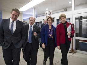 From left, Sen. Jeff Flake, R-Ariz., Sen. Chris Coons, D-Del., Sen. Amy Klobuchar, D-Minn., and Sen. Jeanne Shaheen, D-N.H., arrive at the Capitol after a bipartisan group of moderate senators held a private meeting on Day 2 of the federal shutdown, at the Capitol in Washington, Sunday, Jan. 21, 2018. Sen. Angus King, I-Vt., is seen at rear.