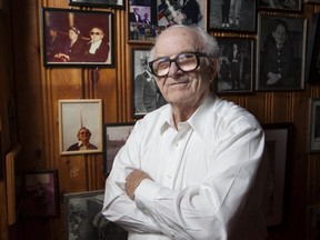 Red Fisher poses for a photograph next to two photos from Moscow in 1972, top left and photo underneath, in his memorabilia room at his home in Côte-St-Luc in Montreal on Friday, August 31, 2012. In the top photo, Fisher, right, is seated next to an unknown woman in a Moscow métro car in 1972. Underneath, Fisher poses in front of the Monument to the Conquerors of Space in Moscow in 1972.