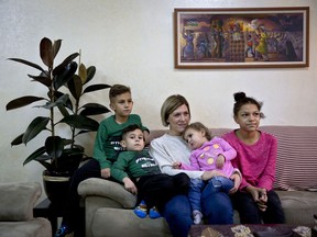 In this Wednesday, Jan. 10, 2018 photo, Kate Hamad, originally from Grimes, Iowa, sits with her children during an interview with The Associated Press in Ramallah, West Bank. Hamad doesn't dare leave Ramallah, fearing deportation if stopped at an Israeli checkpoint on the outskirts of the autonomous Palestinian city. Activists say Israel is making it harder for foreigners with ties to Palestinians to stay in the West Bank legally, rejecting more visa requests or issuing them for shorter period. Israel denies it's adopted tougher rules.