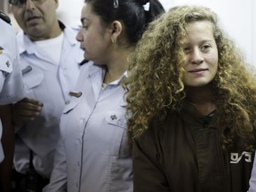 FILE - In this Dec. 28, 2017 file photo, Ahed Tamimi is brought to a courtroom inside Ofer military prison near Jerusalem. A senior Israeli official on Wednesday said he led a secret investigation into 16-year-old Palestinian protest icon Ahed Tamimi and her family, in part because their appearance, including "blond-haired, freckled" children in "Western clothes," made them seem less like "real" Palestinians.