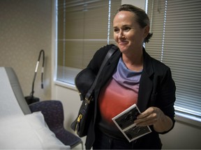 Brigitte Adams holds sonogram prints of her pregnancy at the Center for Fetal Medicine in Los Angeles.