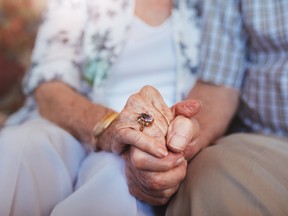 Elderly couple holding hands