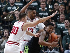 Michigan State's Nick Ward, right, is pressured by Indiana's Juwan Morgan, center, and Collin Hartman, left, during the first half of an NCAA college basketball game, Friday, Jan. 19, 2018, in East Lansing, Mich.
