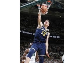 Michigan's Moritz Wagner (13) dunks in front of Michigan State's Jaren Jackson Jr. during the first half of an NCAA college basketball game, Saturday, Jan. 13, 2018, in East Lansing, Mich.