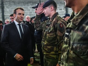 French President Emmanuel Macron speaks with soldiers during his visit to Calais, northern France, Tuesday, Jan.16, 2018. Macron traveled Tuesday to the epicenter of France's migrant crisis, the northern port of Calais, to lay out a "humane and tough" immigration policy that involved better behavior by security forces and closer cooperation with Britain.