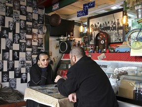 Two young Iranians sit in a fast food restaurant in downtown Tehran, Iran, Wednesday, Jan. 3, 2018. Tens of thousands of Iranians took part in pro-government demonstrations in several cities across the country on Wednesday, Iranian state media reported, a move apparently seeking to calm nerves after a week of protests and unrest that have killed at least 21 people.