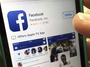 In this Monday, June 19, 2017, file photo, a user gets ready to launch Facebook on an iPhone, in North Andover, Mass. Facebook and record label Universal Music Group have signed a multiyear deal that will let Facebook users share videos that have the label's music in them.