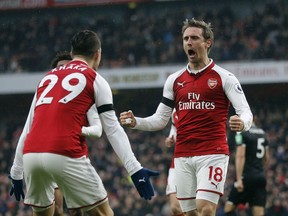 Arsenal's Nacho Monreal, center, celebrates with teammates after scoring his side's first goal during the English Premier League soccer match between Arsenal and Crystal Palace at the Emirates stadium in London, Saturday, Jan. 20, 2018.