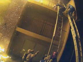 Helmet video footage captured the dramatic moment when a parent escaping an apartment fire threw their child to a firefighter on the ground.