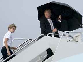 President Donald Trump and his son Barron board Air Force One at Palm Beach International Airport in West Palm Beach, Fla., Monday, Jan. 15, 2018, to travel to Washington. President Trump spent the holiday weekend at Mar-a-Lago, his club in Palm Beach, Fla.