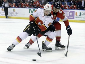 Andrew Mangiapane of the Calgary Flames makes a power move on Florida Panthers' defenceman Alexander Petrovic during NHL action Friday night in Sunrise, Fla. The Flames were 4-2 iwnners, extending their winning streak to six games.