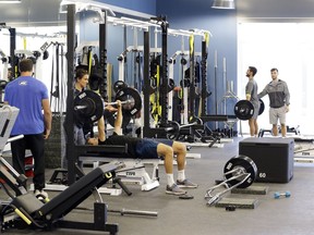 In this Tuesday, Dec. 12, 2017, photo, tennis players work out in the gym at the USTA National Campus in Orlando, Fla.  It's where dozens of professional players from the country go through preseason preparations.