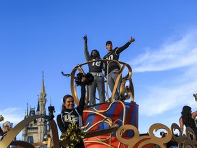 Central Florida football players Shaquem Griffin, left, and McKenzie Milton wave to fans during the a parade at Walt Disney World in the Magic Kingdom on Sunday, Jan. 7, 2018, in Orlando, Fla.