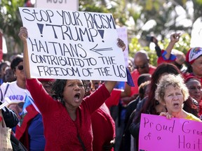 FILE- This Jan. 15, 2018, file photo shows Haitian community supporters in West Palm Beach, Fla., to protest recent remarks made by President Donald Trump about Haiti. The NAACP has sued the U.S. Department of Homeland Security. The organization says Trump's disparaging comments about immigrants and their home countries is evidence of racial discrimination that has influenced his administration's decision to end protections for roughly 60,000 Haitians.