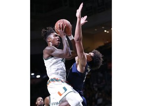 Miami guard Lonnie Walker IV, left, takes a shot against Pittsburgh forward Kene Chukwuka (15) during the first half of an NCAA college basketball game, Wednesday, Jan. 31, 2018, in Coral Gables, Fla.