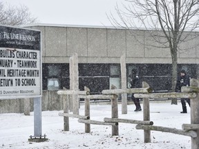 Two police officers walk around Pauline Johnson Junior Public School in Toronto on Monday, January 15, 2018. A Toronto police investigation has concluded that an incident reported by an 11-year-old girl who claimed her hijab was cut by a scissors-wielding man as she walked to school did not happen.