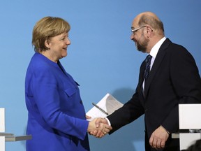 FILE - In this Jan. 12, 2018 file photo German Chancellor Angela Merkel, left, shakes hand with Social Democratic Party Chairman Martin Schulz during a joint statement after the exploratory talks between Merkel's Christian Democratic block and the Social Democrats on forming a new German government in Berlin, Germany. Supporters and opponents of a new alliance with Chancellor Angela Merkel are making their case to members of Germany's main center-left party who will decide this weekend whether to negotiate a new governing coalition.