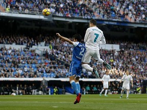 Real Madrid's Cristiano Ronaldo, right, goes for a header with Deportivo Coruna's Juanfran Moreno during a Spanish La Liga soccer match between Real Madrid and Deportivo Coruna at the Santiago Bernabeu stadium in Madrid, Sunday, Jan. 21, 2018.