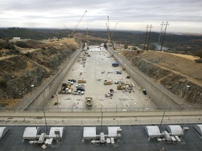 File - In this Oct. 19, 2017 file photo, crews work to repair the damaged main spillway of the Oroville Dam in Oroville, Calif. National dam safety experts say long-term and systemic failures by officials in California and elsewhere caused last year's near-disaster at the nation's tallest dam. The report released Friday, Jan. 5, 2018, comes from experts appointed to investigate the causes of spillway collapses at California's Oroville Dam.