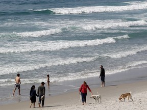 File - In this March 19, 2014 file photo, visitors converge on the beach in Carmel, Calif. Several beaches along California's Central Coast are closed after nearly five million gallons of sewage spilled into the ocean in Monterey County. The county's Environmental Health Department says the massive spill was stopped Saturday, Jan. 21, 2018, at the Monterey One Water wastewater treatment facility. At least eight beaches are closed in the area about 110 miles south of San Francisco.