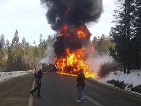 In this photo provided by Steve Corso people watch as flame rise from a deadly crash between a pickup and a fuel tanker Wednesday, Jan. 31, 2018, that shut down a stretch of U.S. Highway 20 west of Truckee, Calif. California Highway Patrol Officer Chris Nave said both drivers were killed in the crash that caused the tanker to explode shortly after 10 a.m. Wednesday.