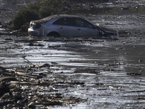 A car sits in flooded water in Montecito, Calif., Thursday, Jan. 11, 2018. Rescue workers slogged through knee-deep ooze and used long poles to probe for bodies Thursday as the search dragged on for victims of Tuesday's storm after mudslides slammed this wealthy coastal town.