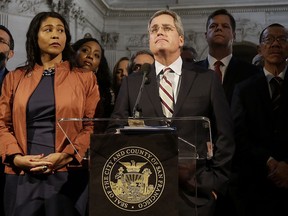 FILE - In this Dec. 12, 2017 file photo, City Attorney Dennis Herrera, center, speaks at a news conference next to acting mayor London Breed, left, at City Hall in San Francisco. Candidates face a deadline, Tuesday, Jan. 9, 2018, to enter the 2018 race for mayor, a contest moved up by more than a year after the sudden death of Mayor Ed Lee last month.