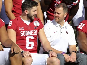 Oklahoma quarterback Baker Mayfield talks with coach Lincoln Riley during the official team photo at the Rose Bowl on Sunday, Dec. 31, 2017, in Pasadena, Calif. Georgia plays Oklahoma on Monday in a College Football Playoff semifinal.