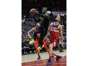 Atlanta Hawks guard Dennis Schroeder (17) drives between Washington Wizards forwards Tomas Satoransky (31) and Otto Porter Jr. (22) during the first half of an NBA basketball game Saturday, Jan. 27, 2018, in Atlanta.