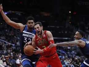 Atlanta Hawks guard Marco Belinelli (3) loses the ball as he drives between Minnesota Timberwolves center Karl-Anthony Towns (32) and guard Jeff Teague (0)in the first half of an NBA basketball game Monday, Jan. 29, 2018, in Atlanta.