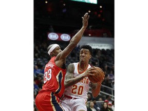 Atlanta Hawks forward John Collins (20) goes up for a shot against New Orleans Pelicans forward Dante Cunningham (33) during the first half of an NBA basketball game Wednesday, Jan. 17, 2018, in Atlanta.