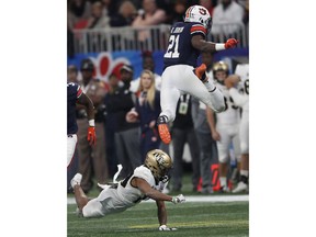 Auburn running back Kerryon Johnson (21) leaps over Central Florida defensive back Mike Hughes (19) during the first half of the Peach Bowl NCAA college football game, Monday, Jan. 1, 2018, in Atlanta.