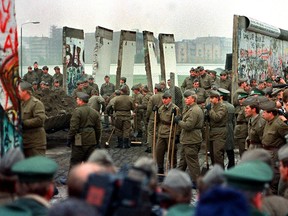 East and West German soldiers remove some of the first sections of the Berlin Wall at Potsdammer Platz in November, 1989.