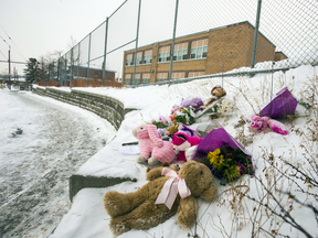 Toys and flowers are left in a snowbank outside St. Raphael Catholic School in Toronto as a memorial to a five-year-old girl who died after being pinned between two SUVs on Monday.