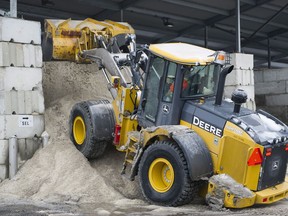 A city worker piles road salt on a mound at a city municipal depot in Montreal, Tuesday, January 23, 2018.