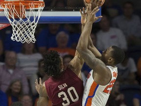 Florida forward Keith Stone, right, has his shot blocked by South Carolina forward Chris Silva (30) during the first half of an NCAA college basketball game in Gainesville, Fla., Wednesday, Jan. 24, 2018.