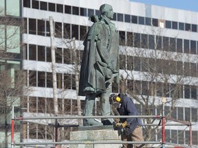 A worker prepares to remove the statue of Edward Cornwallis, a controversial historical figure, in a city park in Halifax on Wednesday, Jan. 31, 2018. Cornwallis, the military officer who founded Halifax in 1749, offered a cash bounty to anyone who killed a Mi'kmaw person.