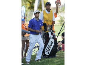 Justin Thomas, left, Jim "Bones" Mackay watch a pairing partner drive off the eight tee box during the third round of the Sony Open golf tournament, Saturday Jan. 13, 2018, in Honolulu. Although he retired last year, MacKay is filling in for Thomas' injured caddie.