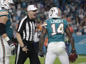 NFL referee Jeff Triplette ejects Miami Dolphins wide receiver Jarvis Landry (14) from the game for unsportsmanlike conduct, during the second half of an NFL football game against the Buffalo Bills, Sunday, Dec. 31, 2017, in Miami Gardens, Fla. To the left is Miami Dolphins offensive tackle Jesse Davis (77).