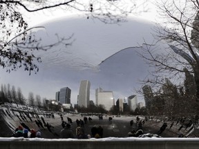 People visit a snow-covered Cloud Gate at Millennium Park in Chicago, Sunday, Dec. 31, 2017. Bitter cold temperatures are affecting parts of the U.S.