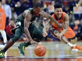 Illinois guard Te'Jon Lucas (3) dives for a loose ball against Michigan State guard Lourawls Nairn Jr. (11) during the first half of an NCAA college basketball game Monday, Jan. 22, 2018, in Champaign, Ill.